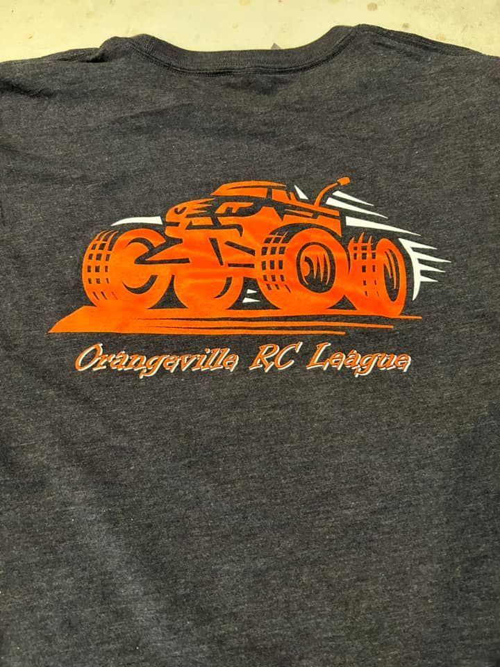 A gray t-shirt with an orange graphic of a monster truck and the text