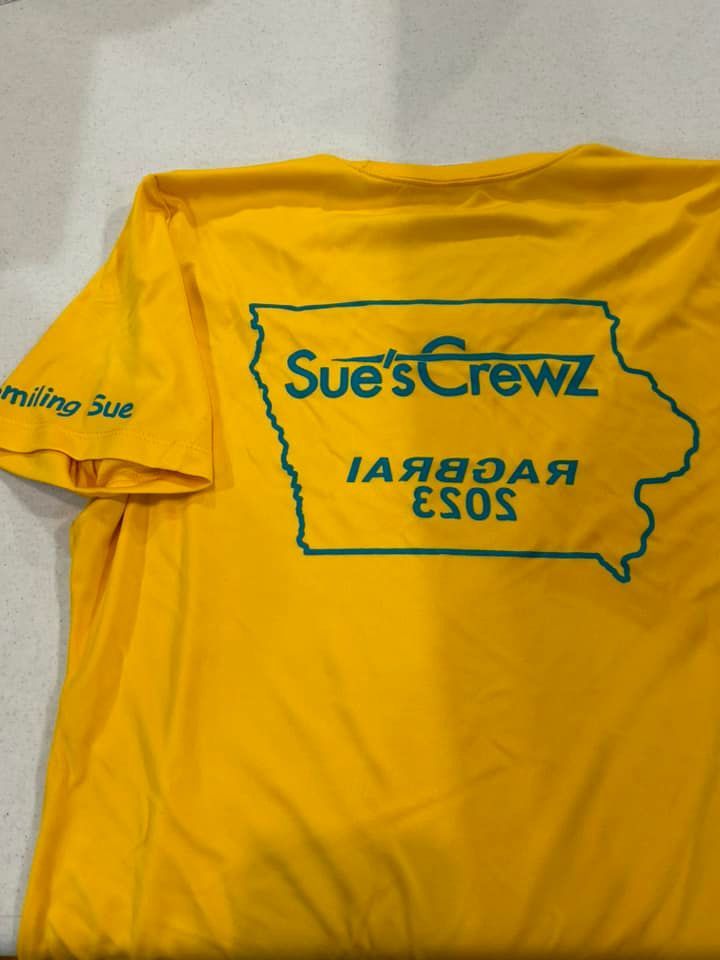 A yellow t-shirt features a green outline of Iowa with the text