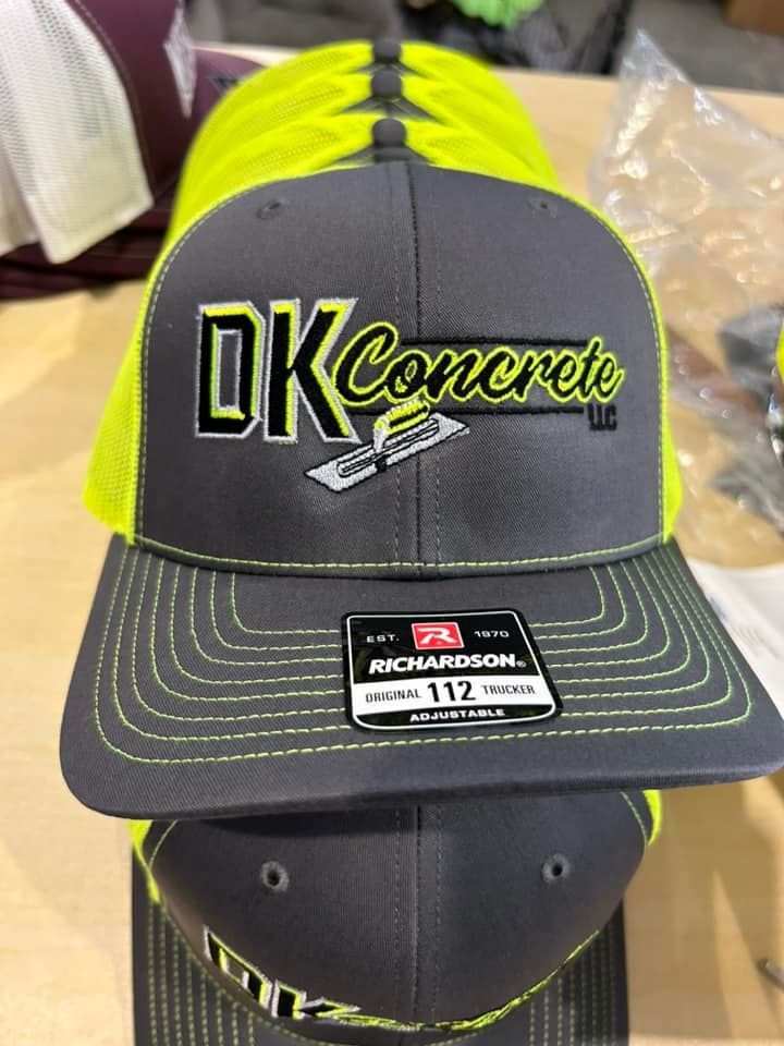 A grey Richardson 112 trucker hat with a neon yellow mesh back and a