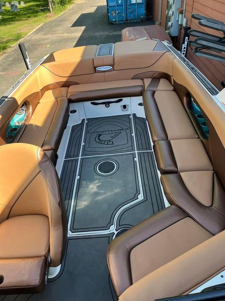 Tan and brown U-shaped outdoor seating around a central gray deck on a boat or dock.