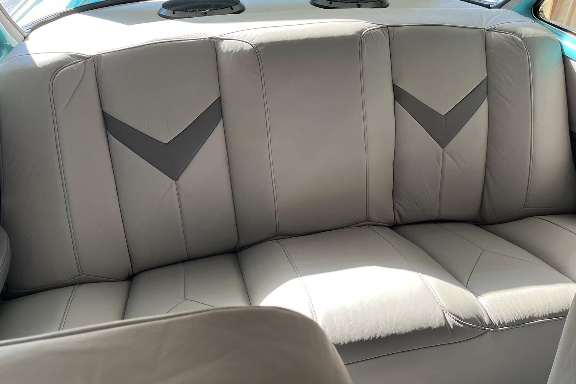 White leather boat bench seat with gray chevron stitching and sunlight across the cushions