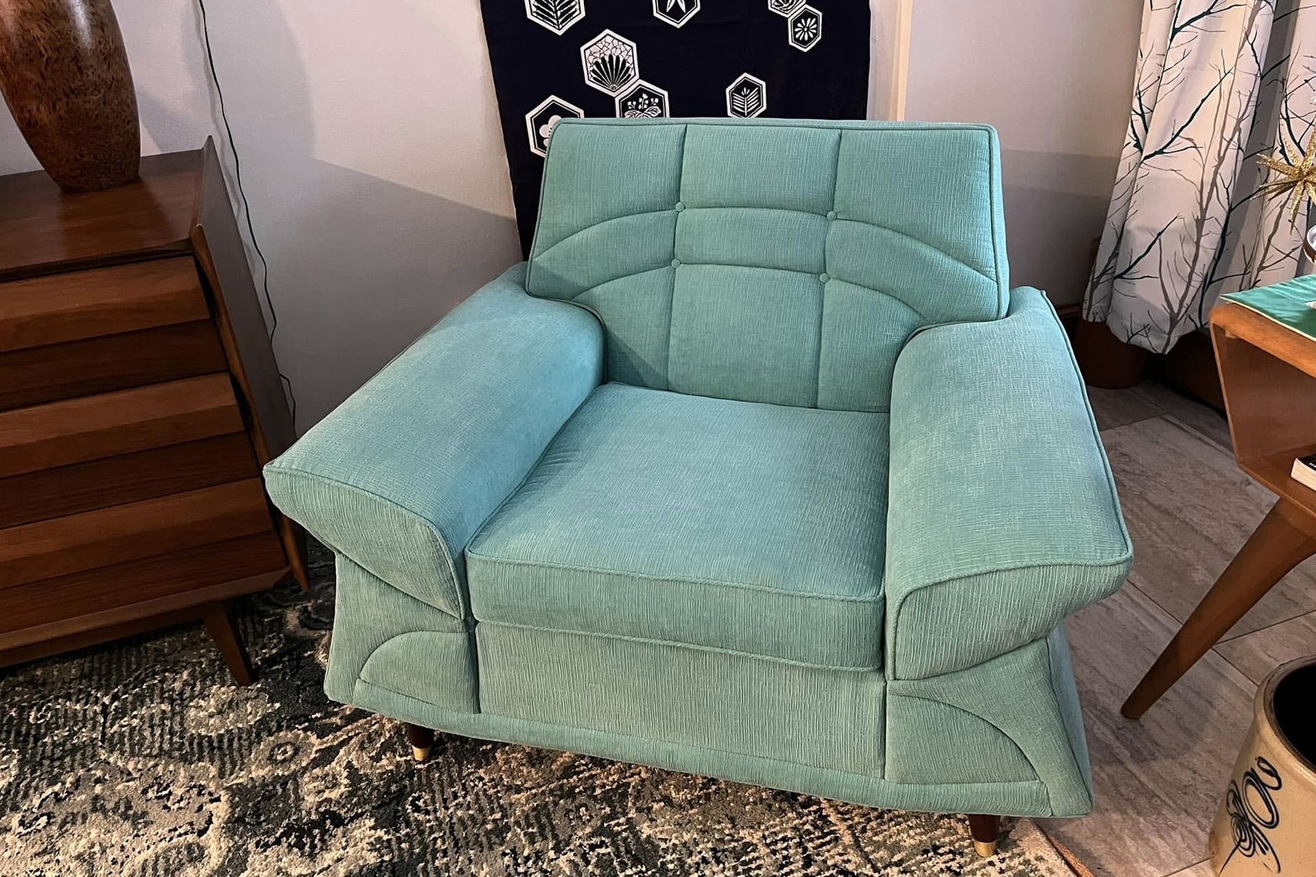 Teal upholstered armchair with textured fabric in a living room