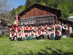 Eine Gruppe von Menschen posiert vor einem Holzgebäude für ein Foto.