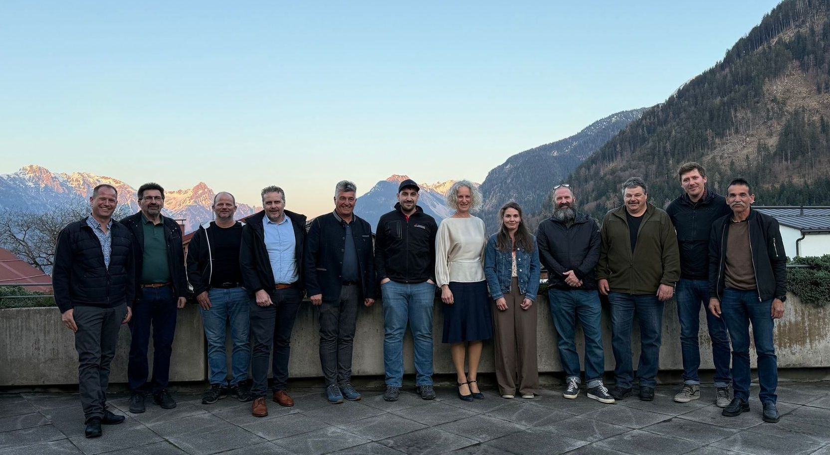 Eine Gruppe von Menschen sitzt in einem Konferenzraum um einen langen Tisch herum.