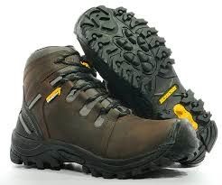 Un par de botas de montaña marrones con suela negra, mostradas una al lado de la otra sobre un fondo blanco.