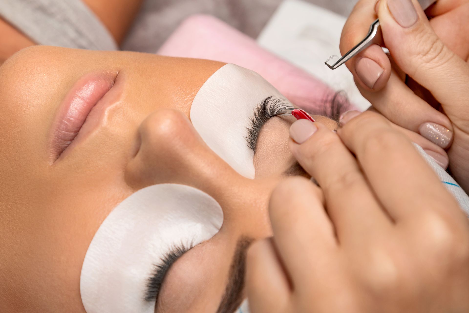 A woman is getting her eyelashes done at a beauty salon.