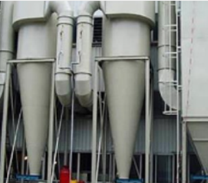 Two tall, light-gray industrial cyclone dust collectors mounted on metal frames against an industrial facility wall.