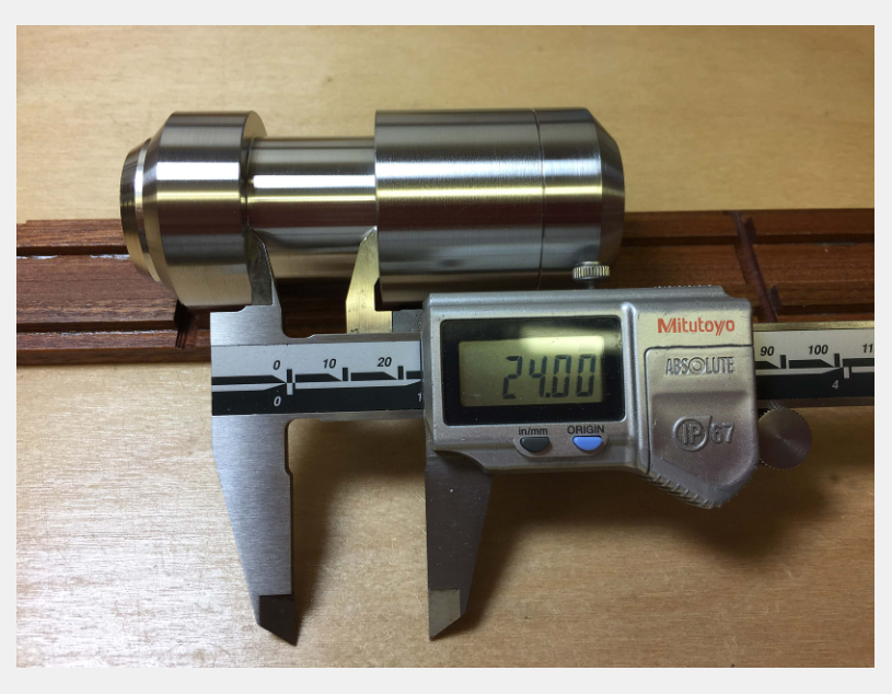 A digital Mitutoyo caliper measuring a cylindrical metal part, showing a reading of 24.00 millimeters.