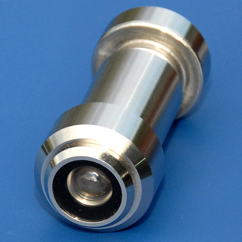 A shiny, cylindrical metal door peephole lens isolated against a blue background.