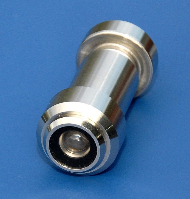 A metallic door peephole lens isolated against a solid blue background.