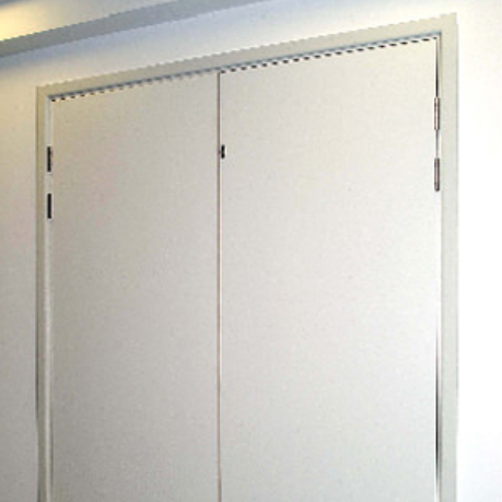 A pair of white, flush-mounted double doors set into a plain white wall, featuring exposed metal hinges along the sides.