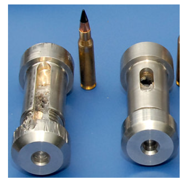 Two machined metal cylindrical components with holes are shown next to a rifle cartridge with a black-tipped projectile.