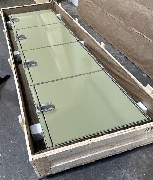 A long, light green rectangular panel with metal latches, packed in a protective wooden shipping crate.