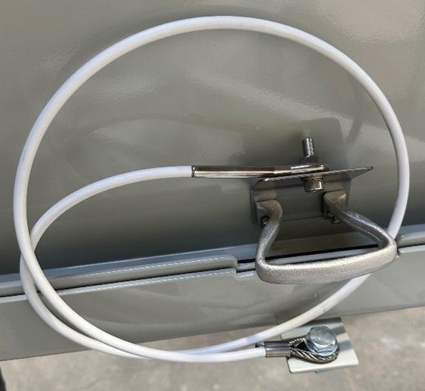 A white safety cable tethered between a metal handle and a mounting bracket on a gray, painted surface.