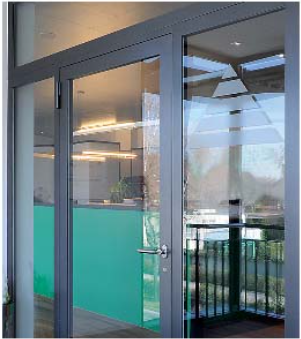 A modern gray-framed glass entrance door with a pyramid-patterned frosted decal, revealing an office interior.