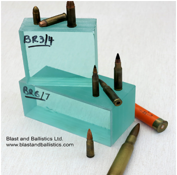 Blocks of ballistic glass labeled BR3/4 and BR6/7, surrounded by various rifle and shotgun ammunition.
