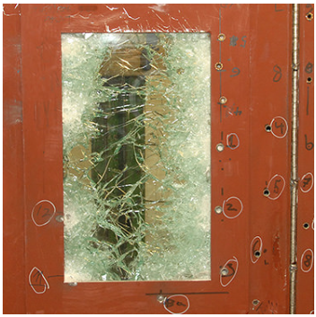 A brown door frame with a shattered glass window insert, showing multiple numbered impact marks around the frame.