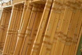 A row of unfinished wooden door frames standing upright in a workshop setting.