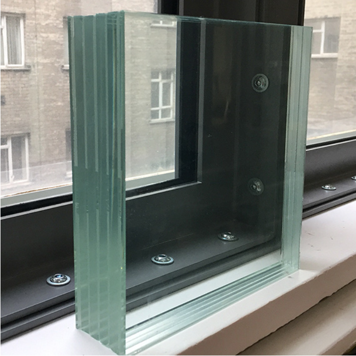 A thick, multi-layered panel of clear laminated safety glass standing on a window sill in front of a window.