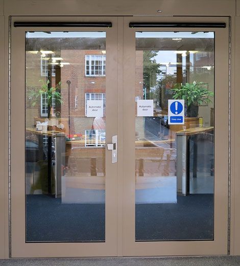 Double glass entry doors in a beige frame with