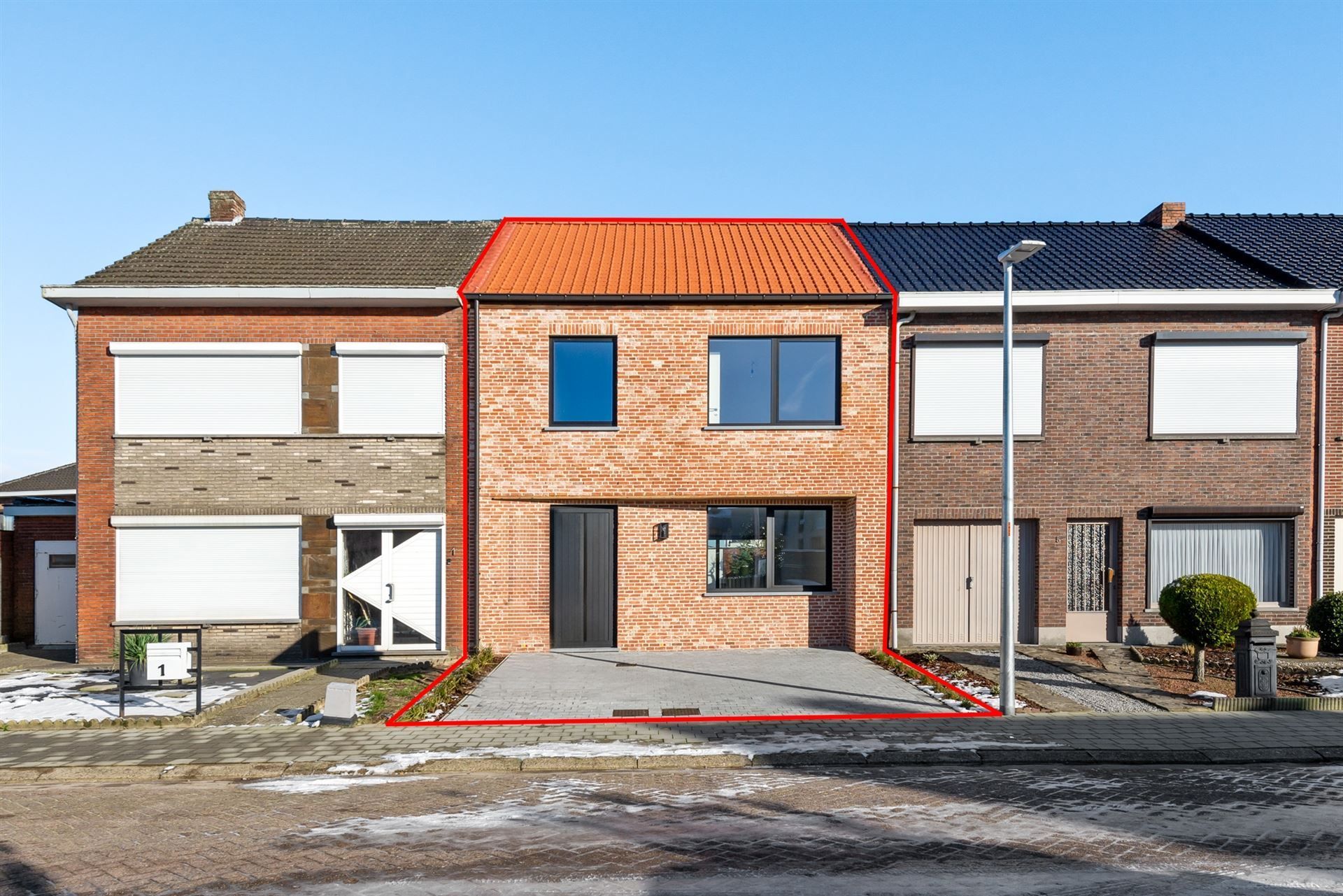 Een rij bakstenen huizen met zonnepanelen op de daken.