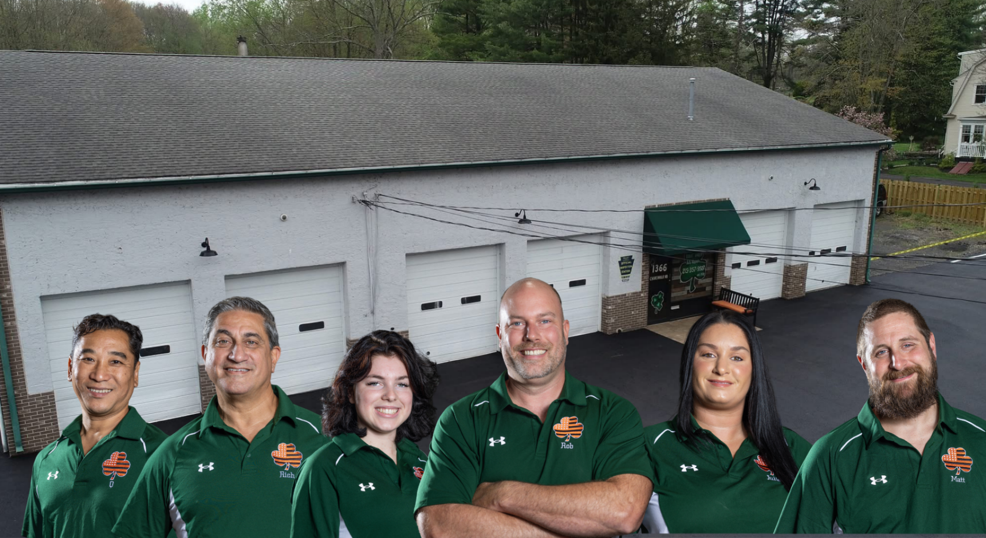 Group of people in green shirts outside a building with a dog, posing for a photo.