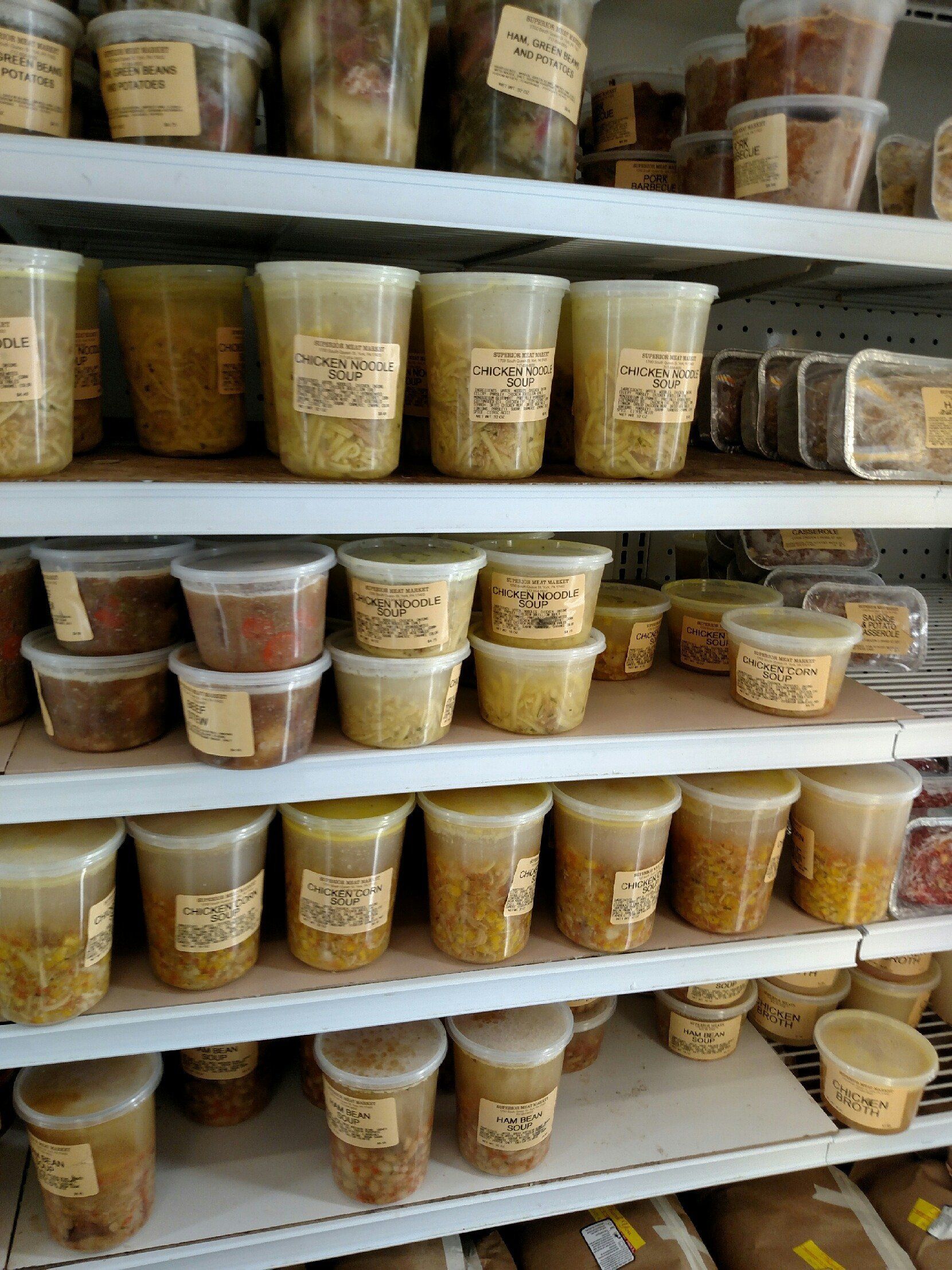 Shelves stocked with plastic tubs of dry goods or spices in a market or pantry aisle