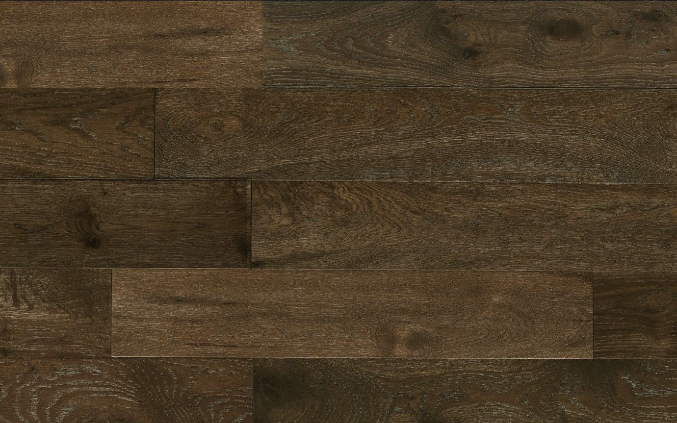 A close up of a wooden floor with a brick wall in the background.