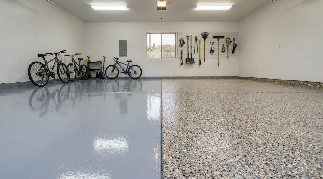 Bright garage with bicycles on the left and a smooth concrete floor showing a speckled finish on the right.