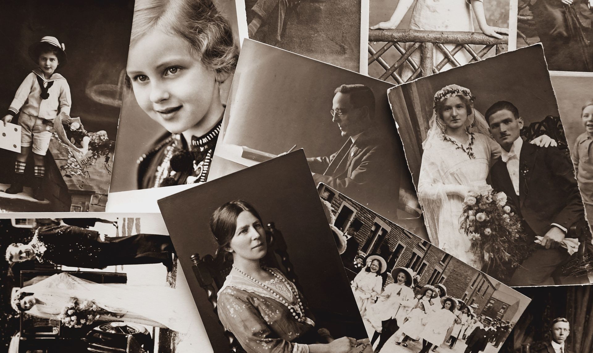 Un collage de photographies de famille et de portraits anciens en noir et blanc, dispersés sur une surface.