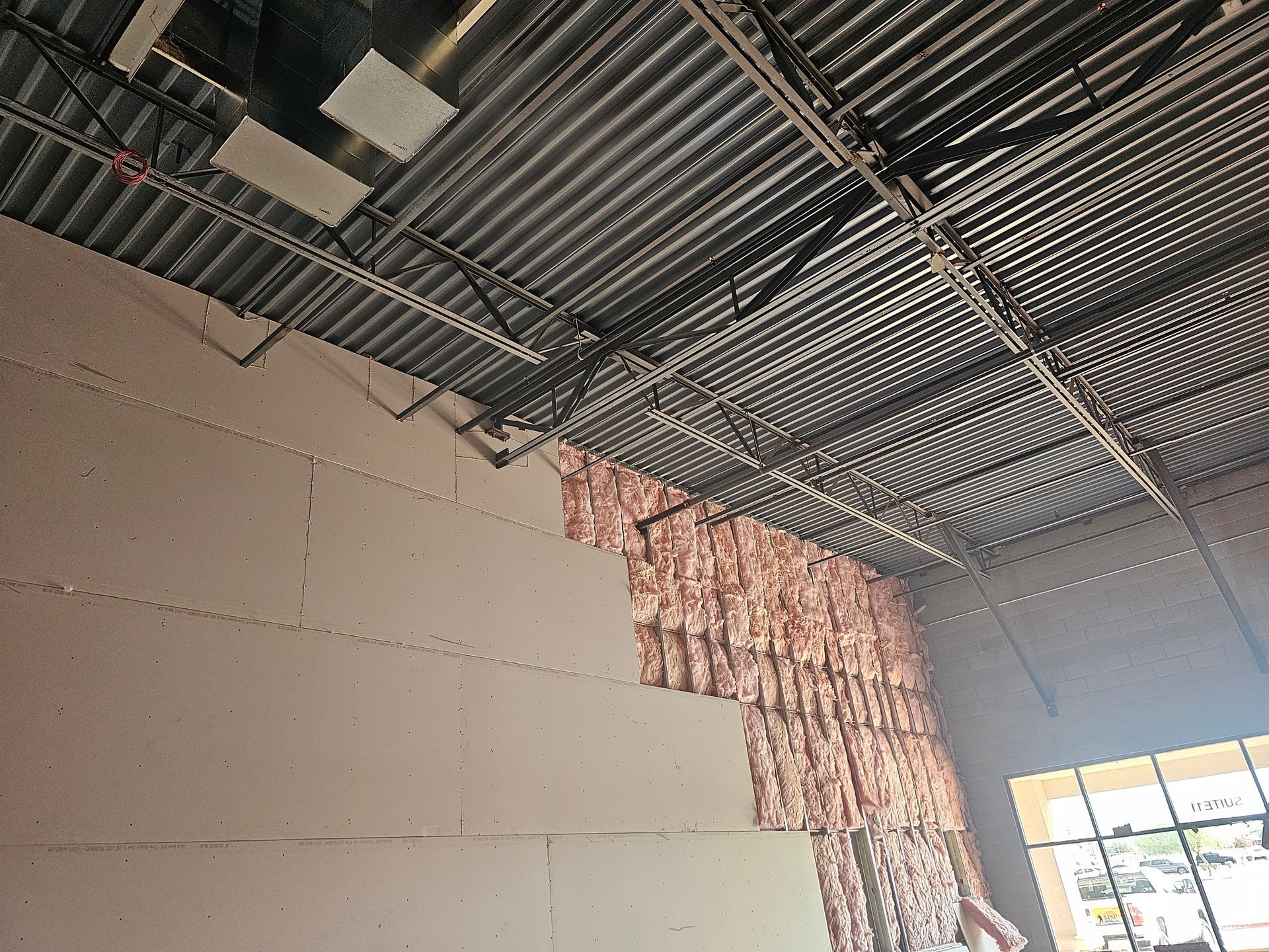 A man is working on a wall in a building under construction.