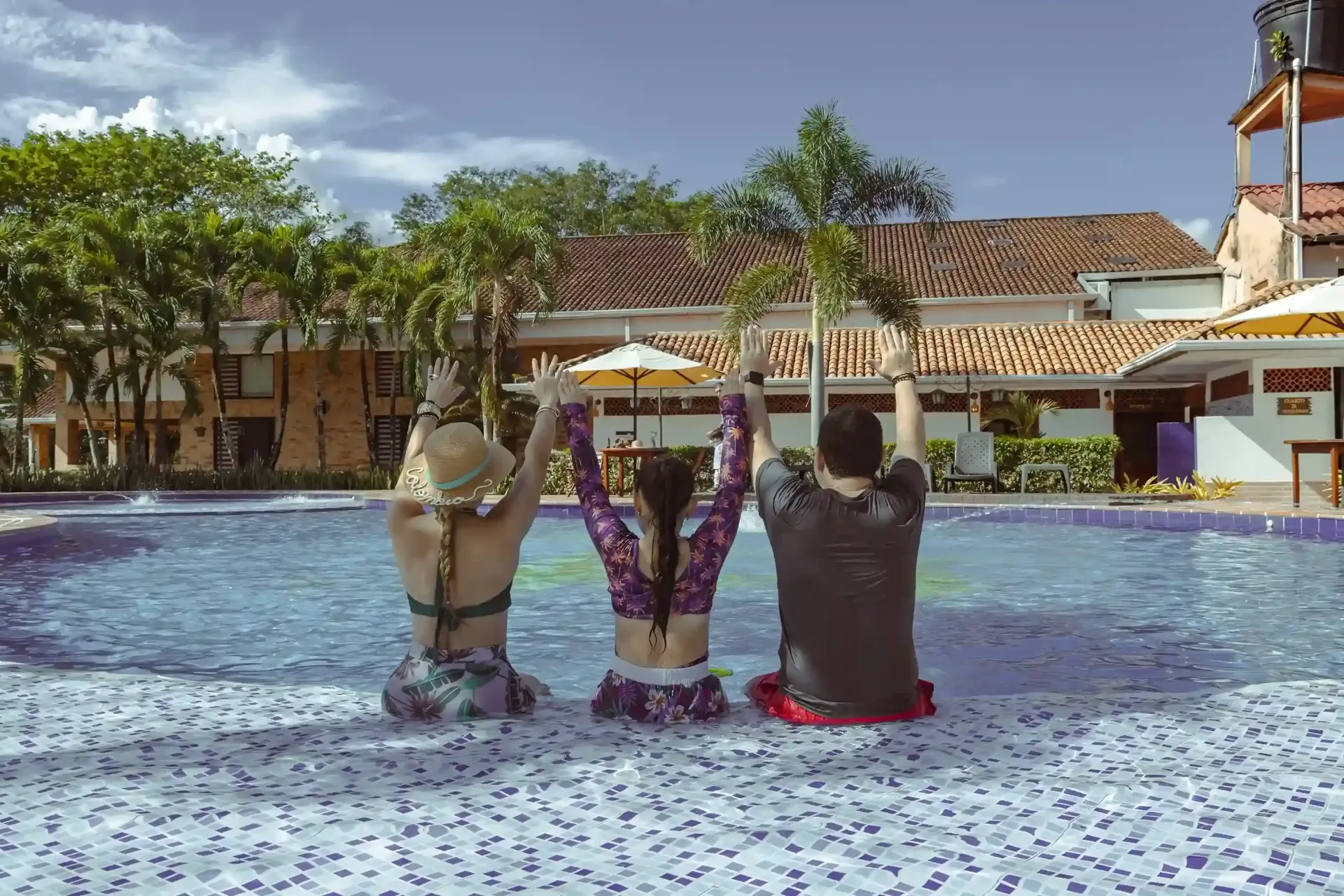 Familia disfrutando la piscina durante pasadías en Villavicencio, plan de descanso en hotel campestre.
