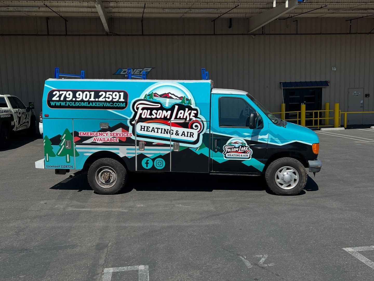 Turquoise and black Sun Lake Heating Air service van parked outside a warehouse, with large phone number on the side.