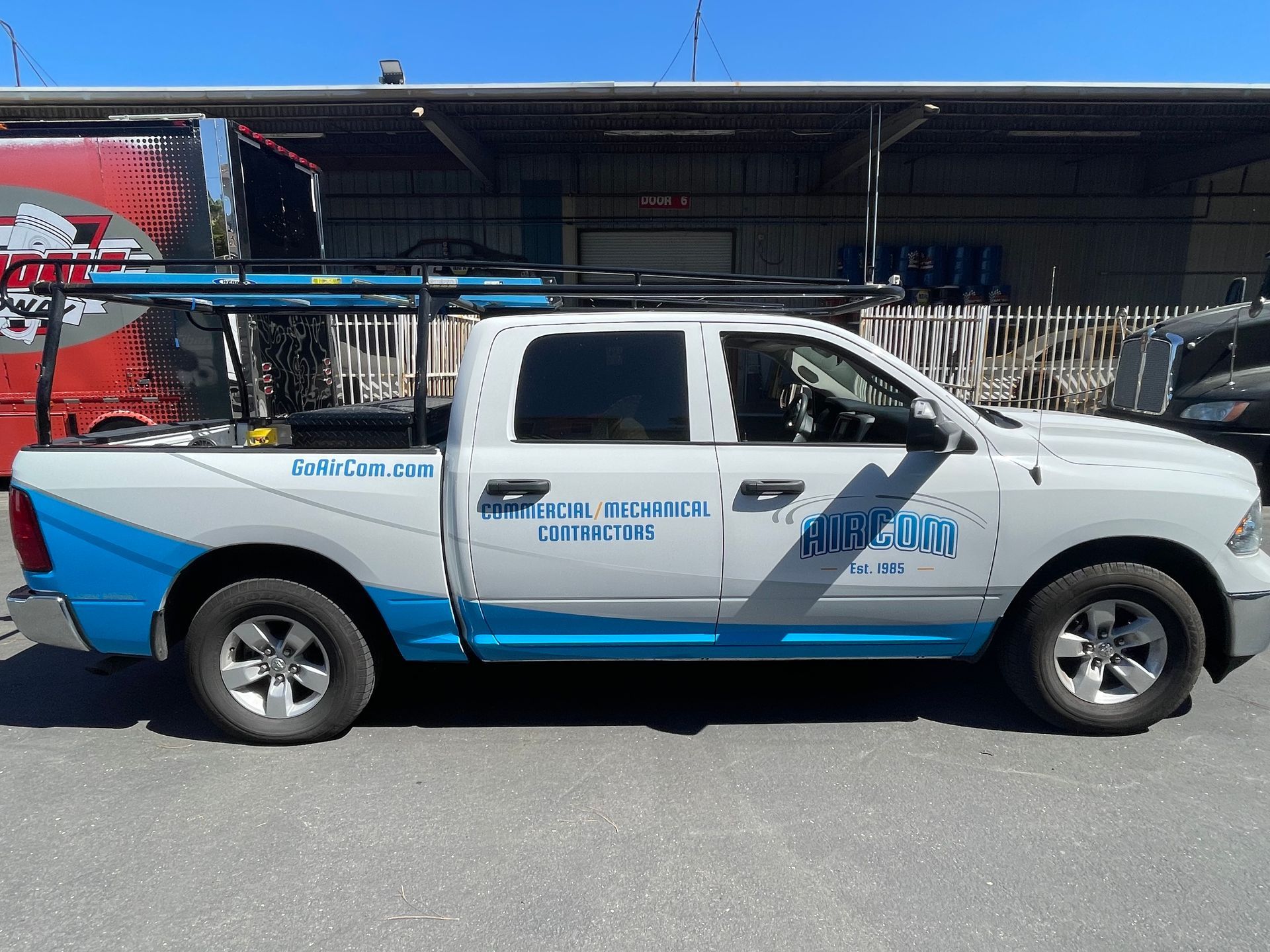 a white and blue truck is parked in front of a building .