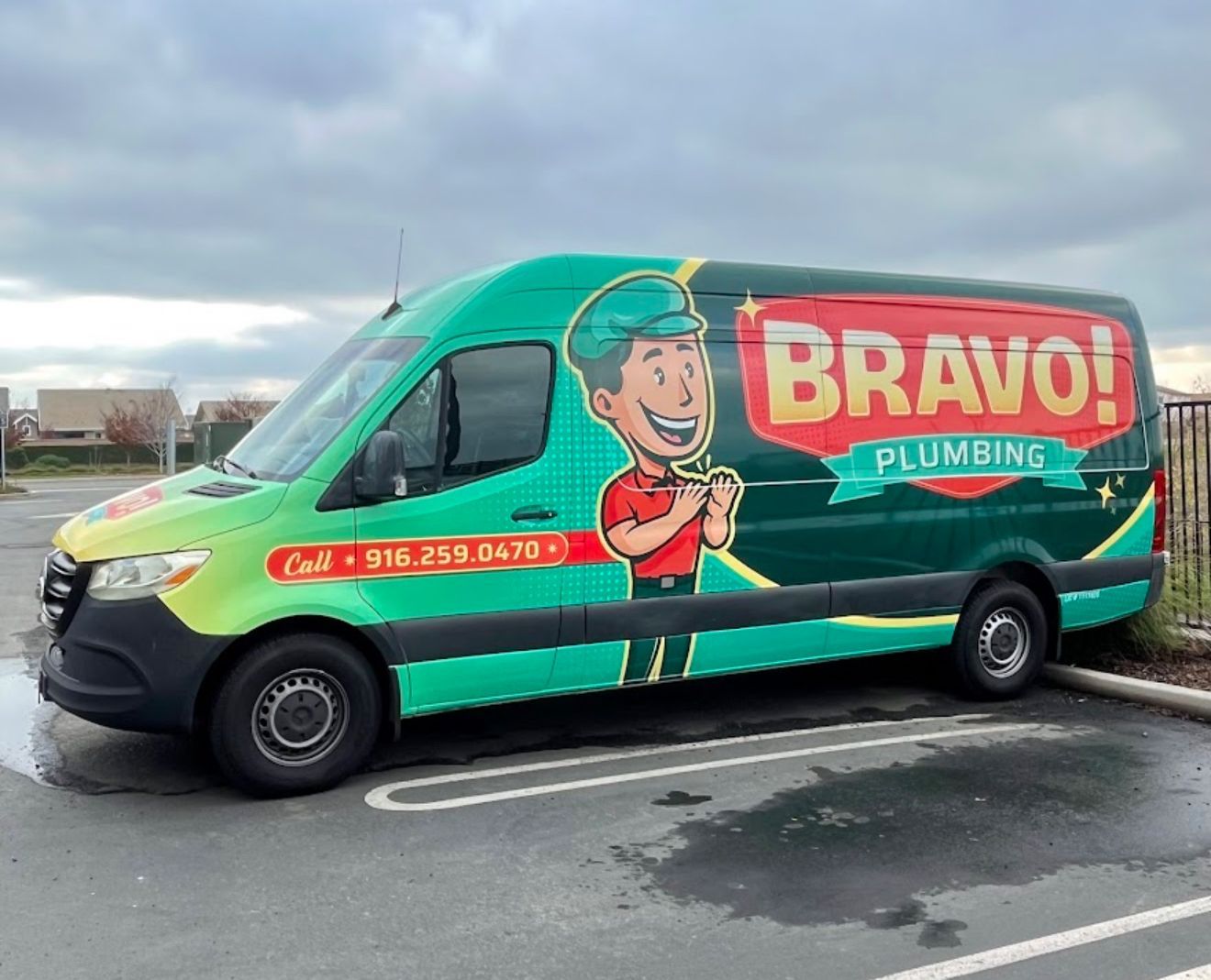 BRAVO Plumbing van with green wrap and smiling cartoon logo parked in a lot