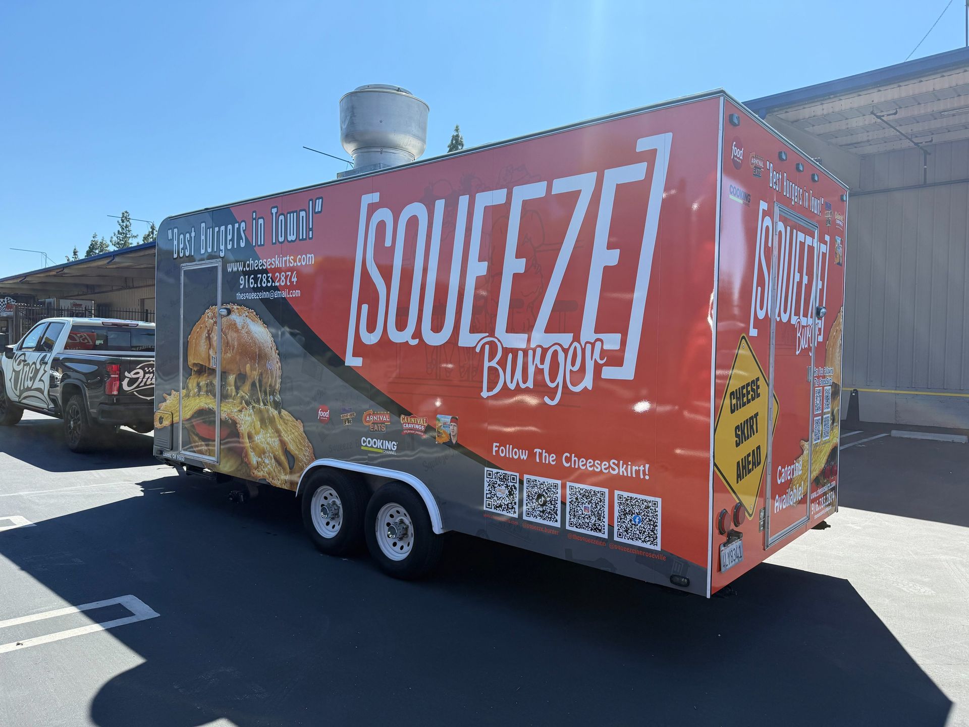 Orange Squeeze Burgers food trailer parked outside on a sunny day