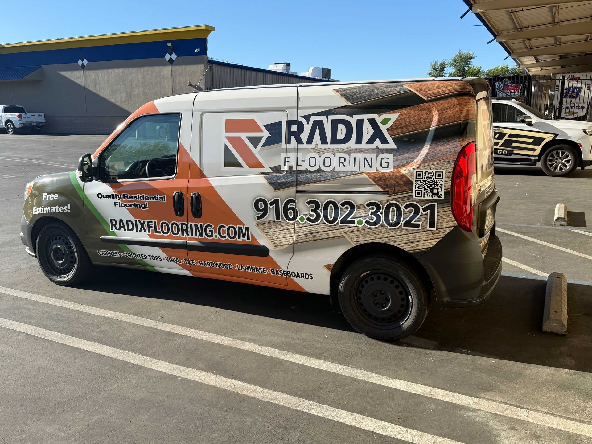 Wrapped RADIX Roofing service van parked in a lot, white and orange with phone number visible
