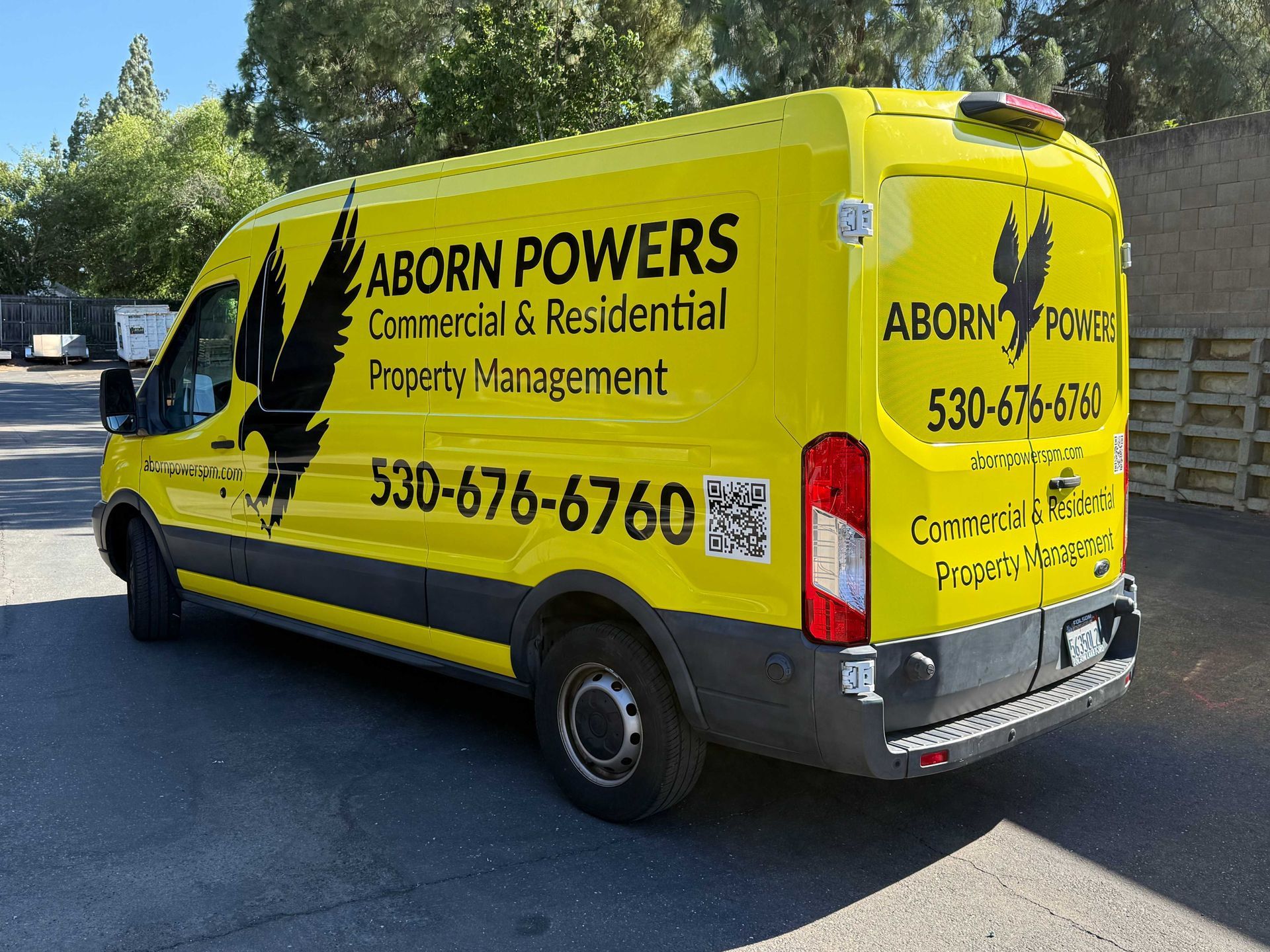 Yellow Aborn Powers service van parked outdoors with company logo and phone number printed on the side