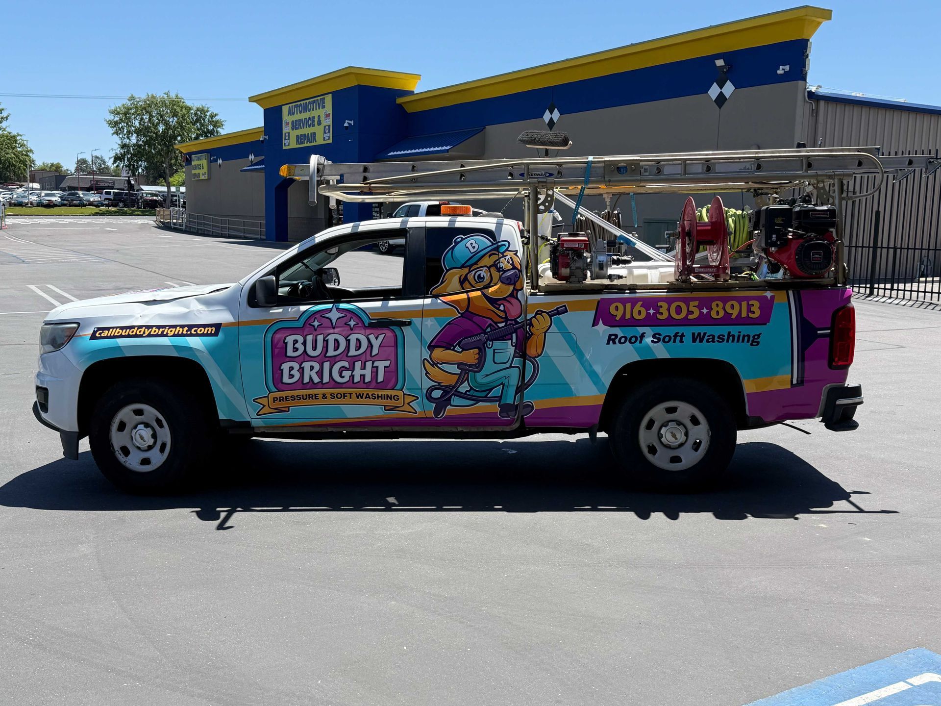 Brightly wrapped service truck parked in a lot with ladders on top and “Buddy Bright” branding on the side