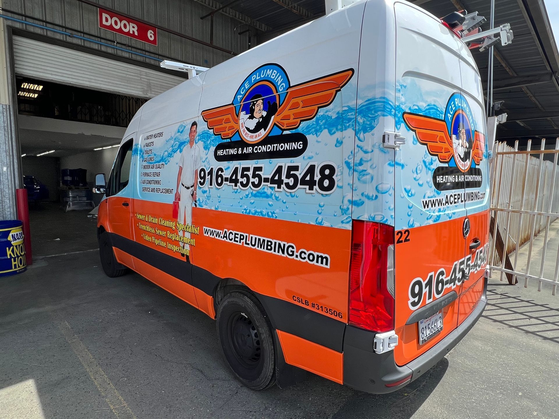 an orange and white van is parked in front of a building .