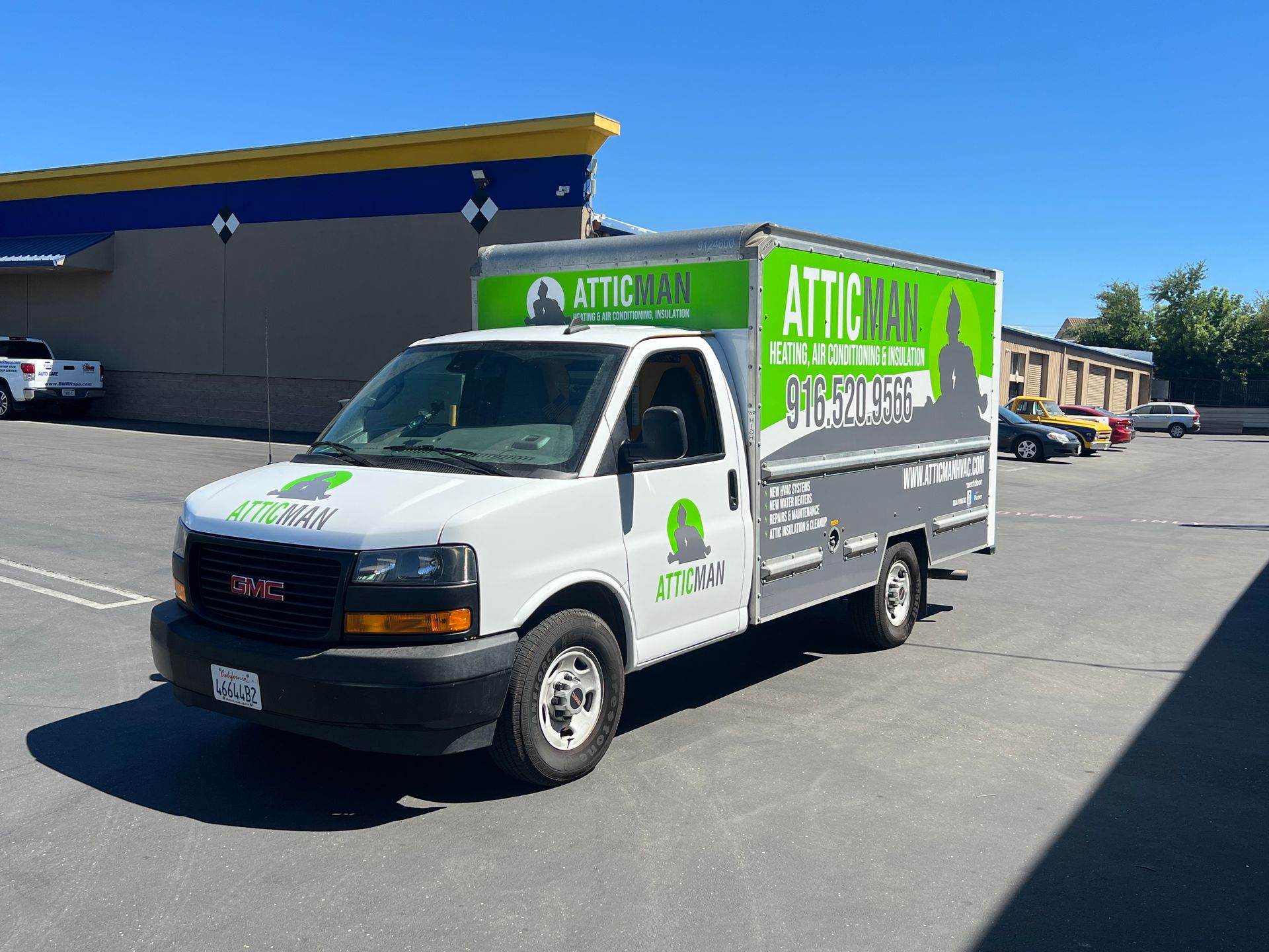 a white van is parked in a parking lot in front of a building .