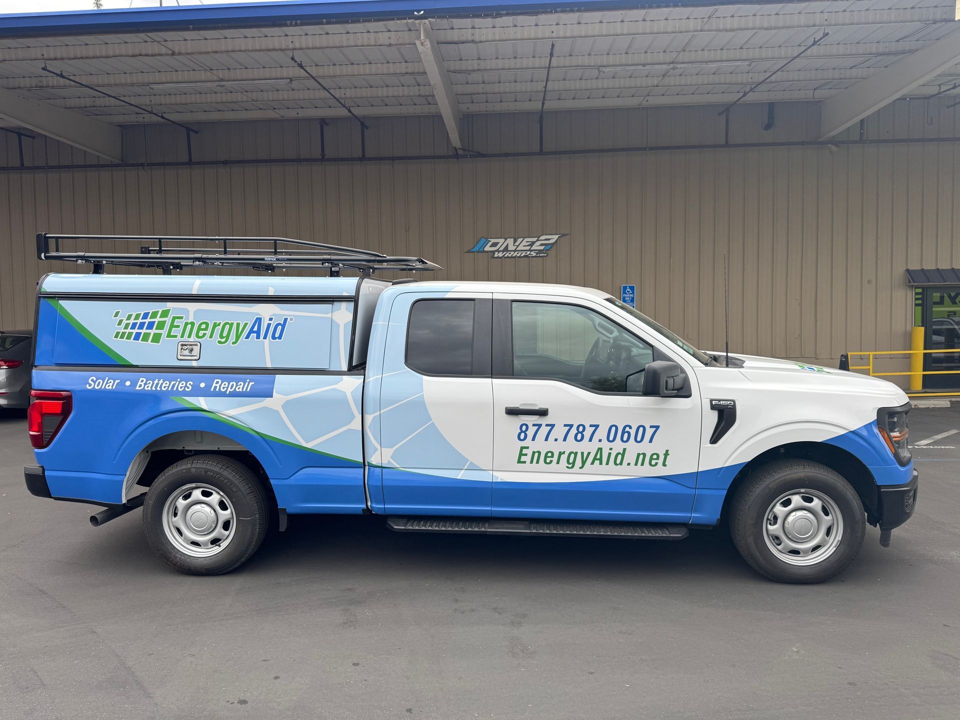 Blue-and-white Energy Air service van parked outdoors by a warehouse wall