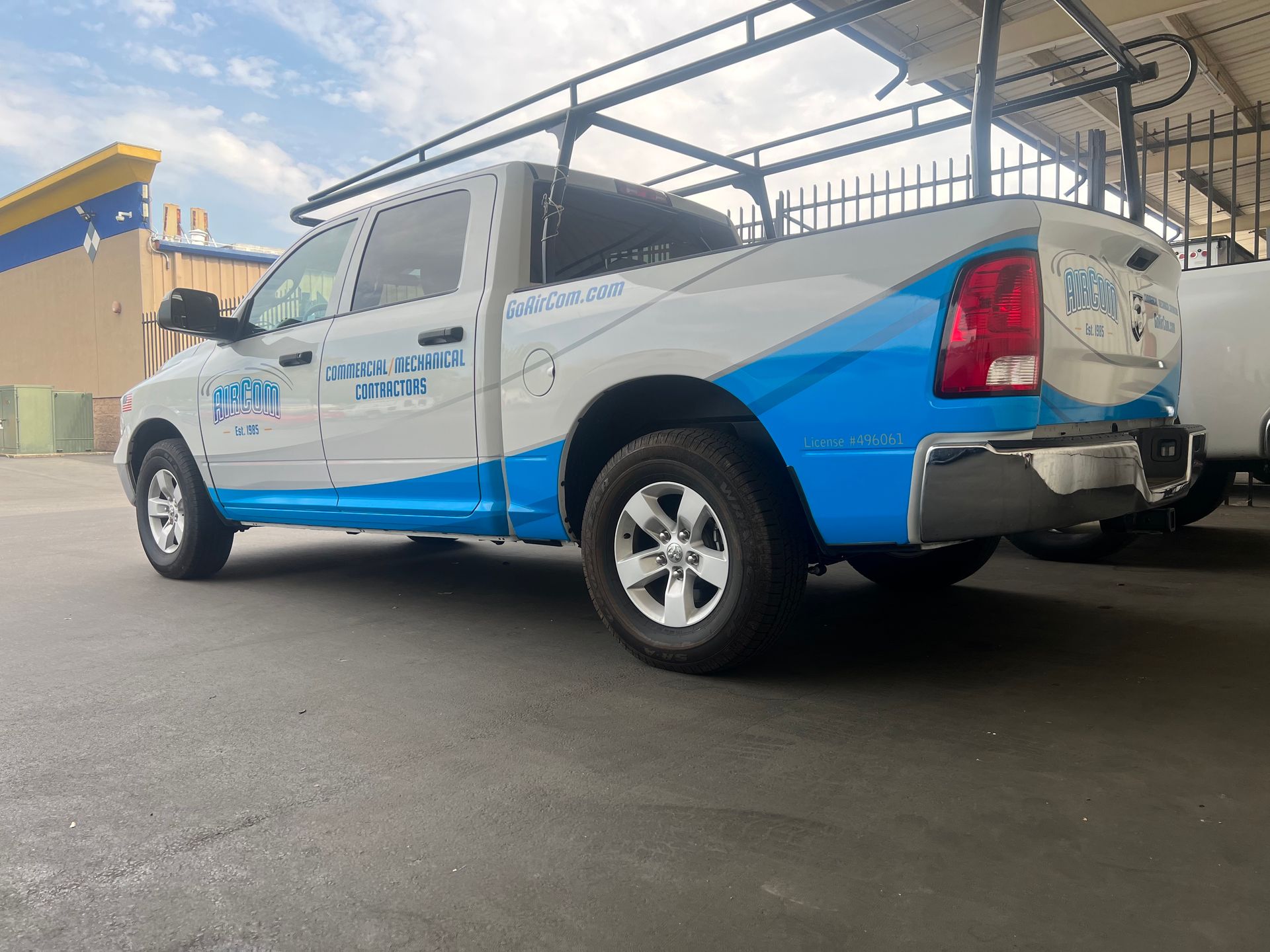 a blue and white truck is parked in a parking lot .