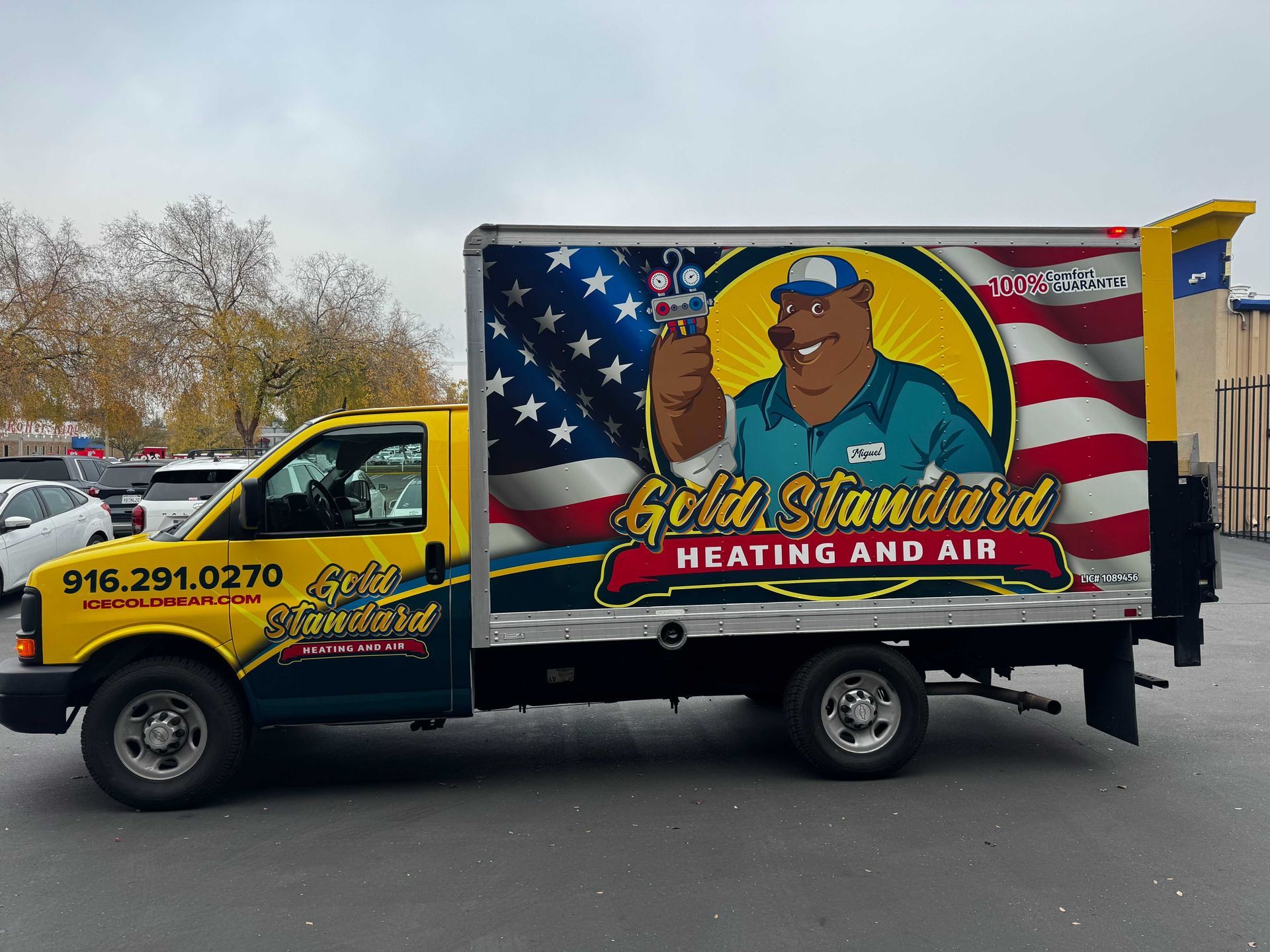 Yellow heating and air service truck with large patriotic logo parked outdoors