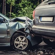 Two cars collided, with heavy damage to the front of a gray sedan and the rear of a dark SUV.