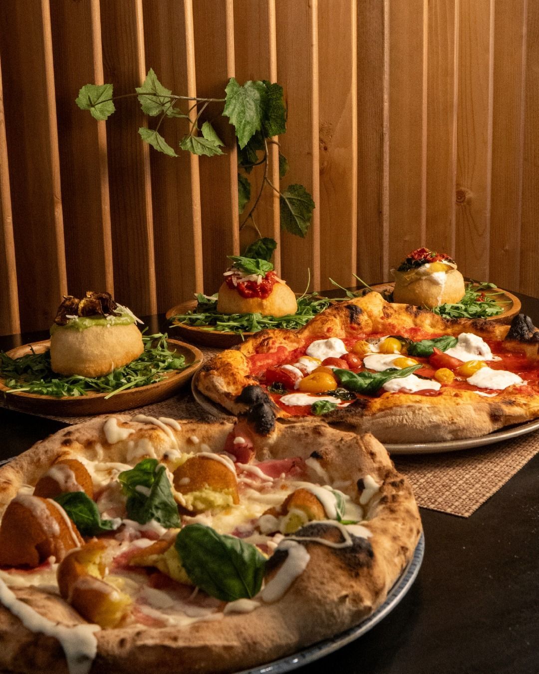 Una pizza Margherita con basilico e formaggio fuso all'interno di una scatola di cartone aperta con l'etichetta Napule.