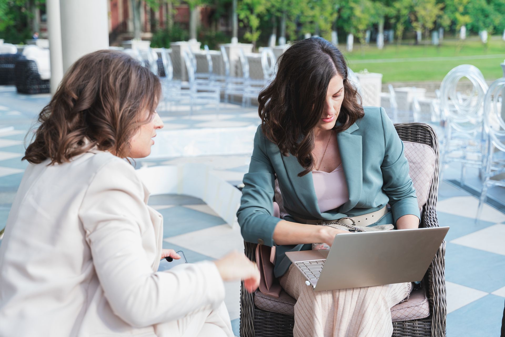 Group of people in business attire at a conference table, reviewing documents and using laptops. Modern office setting. Group of people in business attire at a conference table, reviewing documents and using laptops. Modern office setting.
