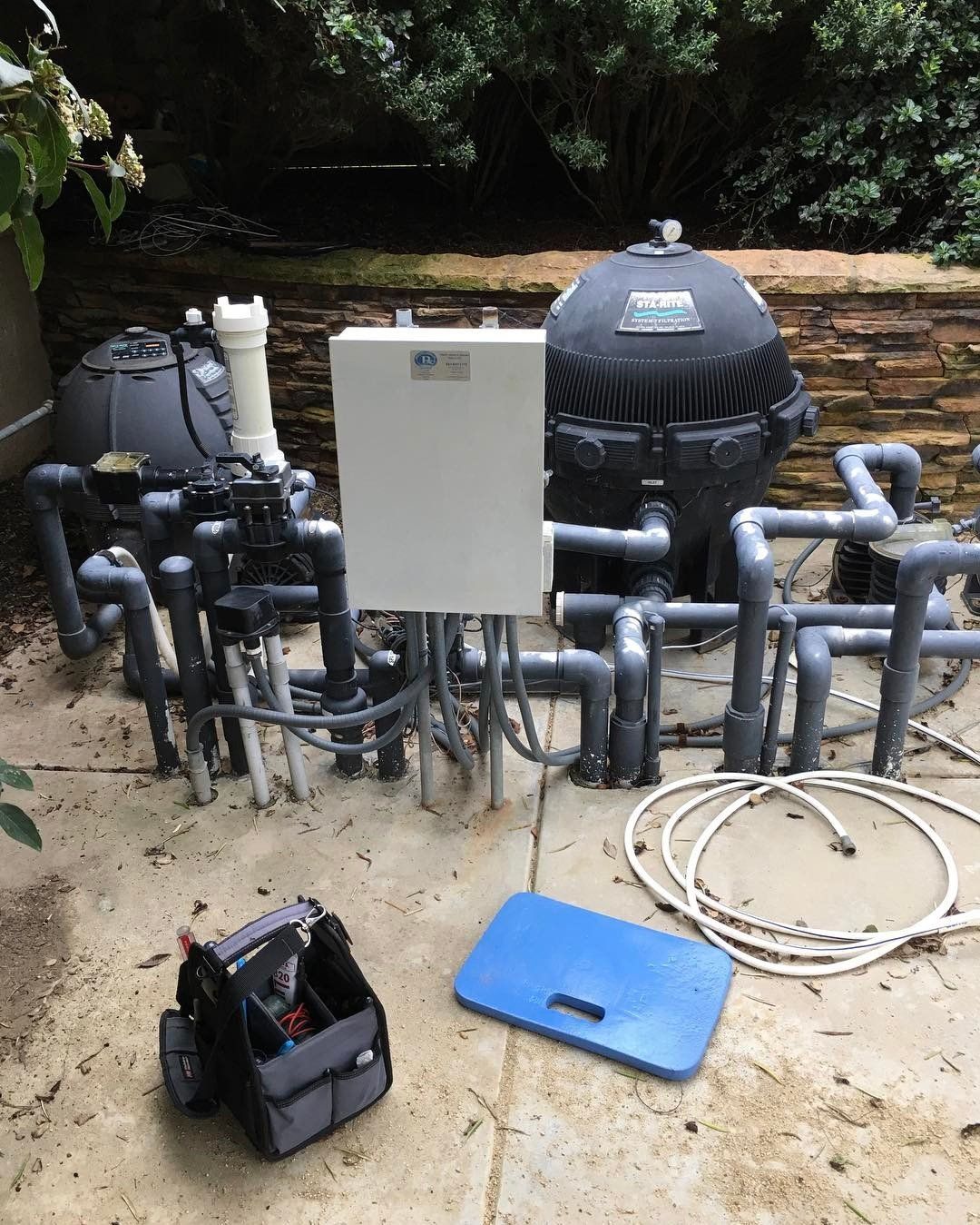 A swimming pool system is being installed on a patio.