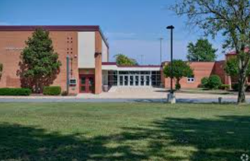 Broad Run Brick school building with central entrance, lawn in front, and trees under a clear blue sky Broad Run Brick school building with central entrance, lawn in front, and trees under a clear blue sky