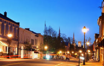 Warrenton street with historic buildings at dusk, blue sky, and light trails from passing cars